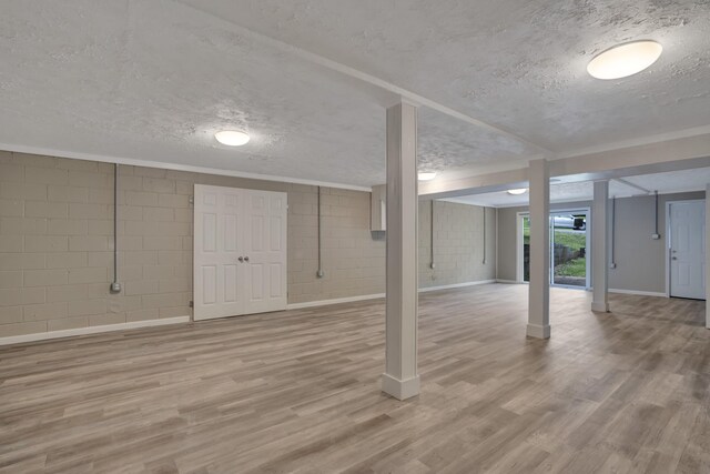 1454 Elm Hill Dr, Clarksville, TN 37040 - below grade area featuring a textured ceiling, wood finished floors, concrete block wall, and baseboards
