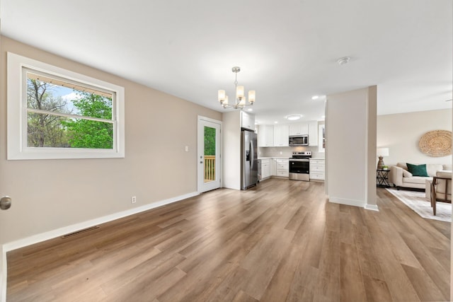 1614 Shady Cir, Lebanon, TN 37087 - unfurnished living room featuring a chandelier, light wood-style floors, and baseboards