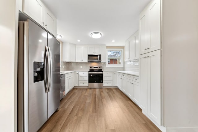 1614 Shady Cir, Lebanon, TN 37087 - kitchen with stainless steel appliances, light wood-type flooring, light countertops, decorative backsplash, and white cabinetry