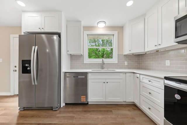 1614 Shady Cir, Lebanon, TN 37087 - kitchen with stainless steel appliances, a sink, white cabinets, tasteful backsplash, and light countertops