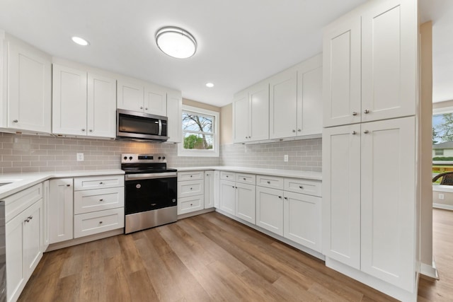 1614 Shady Cir, Lebanon, TN 37087 - kitchen featuring stainless steel appliances, light wood finished floors, light countertops, white cabinetry, and tasteful backsplash