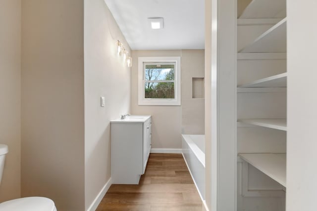 1614 Shady Cir, Lebanon, TN 37087 - bathroom featuring toilet, wood finished floors, baseboards, vanity, and a tub