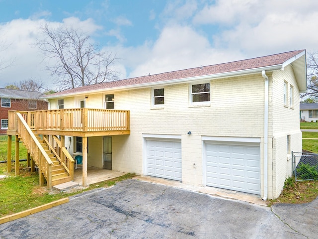 1614 Shady Cir, Lebanon, TN 37087 - back of property with a garage, asphalt driveway, a deck, stairway, and brick siding