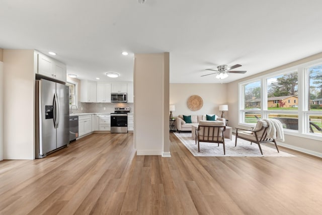 1614 Shady Cir, Lebanon, TN 37087 - kitchen featuring appliances with stainless steel finishes, light countertops, light wood-style flooring, white cabinets, and backsplash