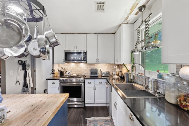 1515 Owen Rd, Brentwood, TN 37027 - kitchen with appliances with stainless steel finishes, butcher block counters, white cabinetry, dark wood finished floors, and decorative backsplash