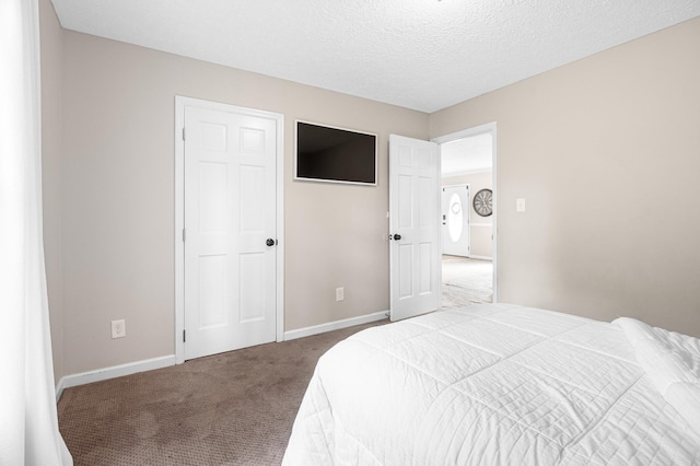 carpeted bedroom featuring baseboards and a textured ceiling