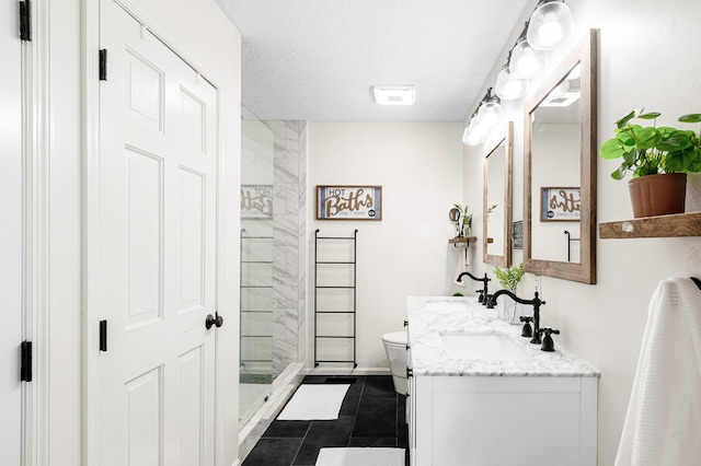 full bath featuring a tile shower, vanity, toilet, tile patterned floors, and baseboards