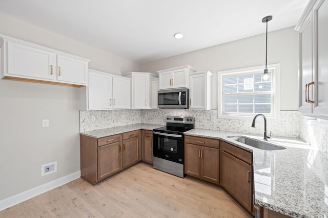 kitchen featuring stainless steel appliances, a sink, white cabinets, tasteful backsplash, and recessed lighting