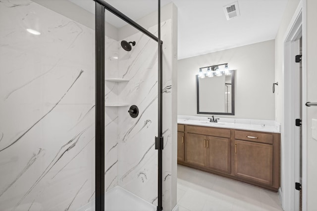 full bathroom featuring a marble finish shower and vanity