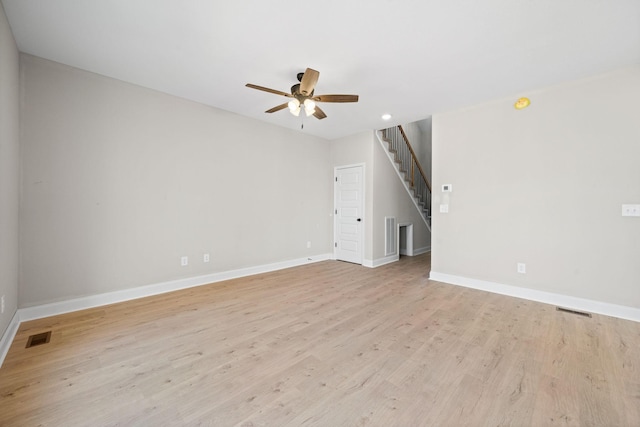unfurnished living room featuring ceiling fan, stairs, light wood-type flooring, baseboards, and recessed lighting