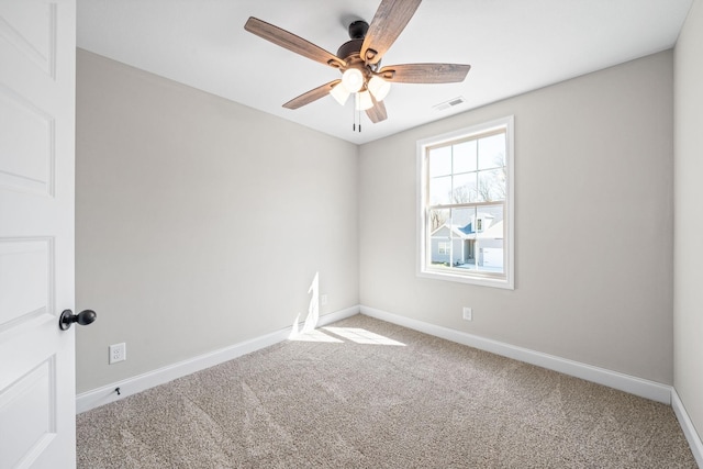 spare room featuring carpet, a ceiling fan, and baseboards