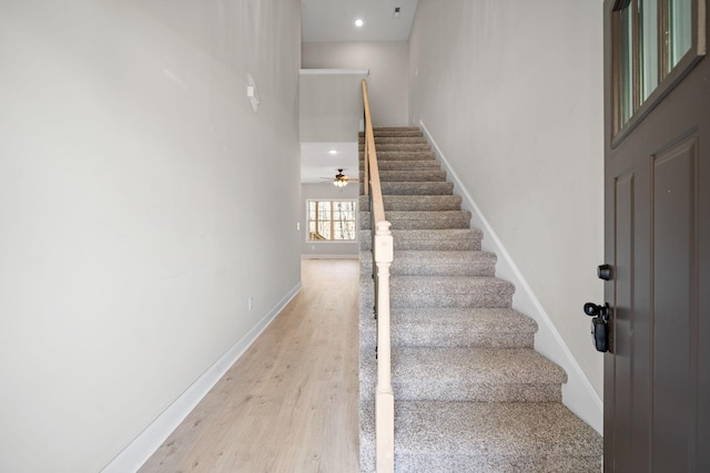 stairs with wood finished floors, baseboards, recessed lighting, and a ceiling fan