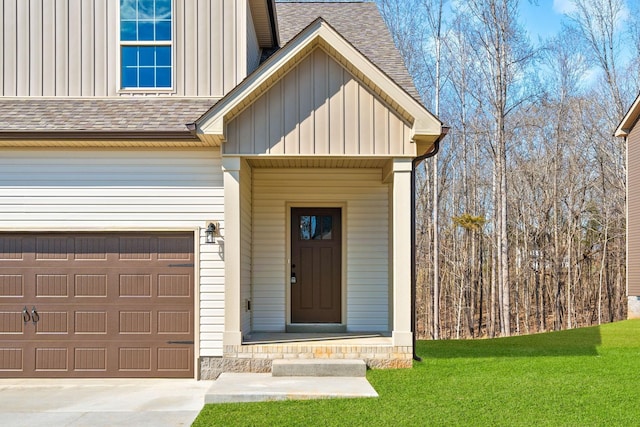 property entrance featuring board and batten siding, a shingled roof, and a yard