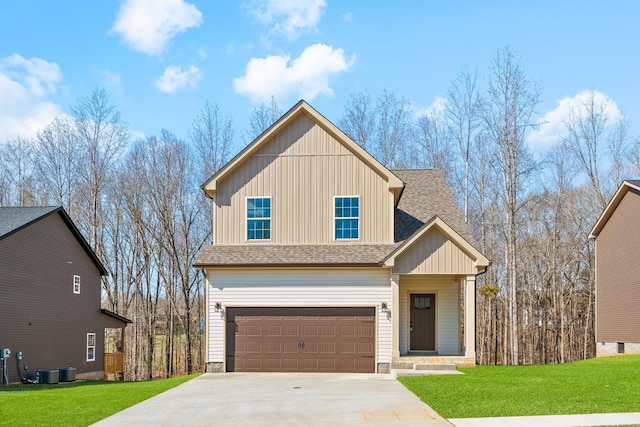 view of front of house with a garage, concrete driveway, roof with shingles, and a front yard