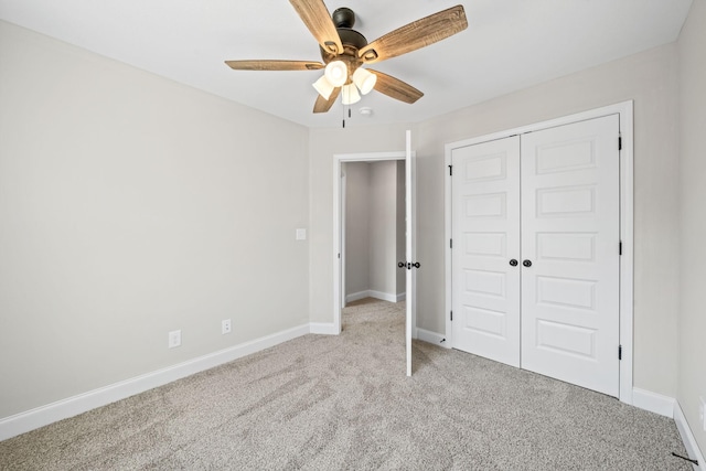 unfurnished bedroom with carpet floors, baseboards, a closet, and a ceiling fan