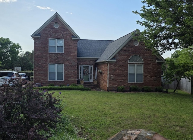 traditional-style home featuring a shingled roof and brick siding