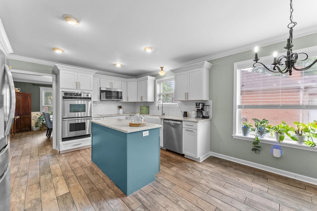 707 Bradford Pl, Murfreesboro, TN 37130 - kitchen with stainless steel appliances, crown molding, light countertops, white cabinets, and a chandelier