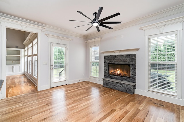 2804 Battleground Dr, Murfreesboro, TN 37129 - unfurnished living room with light wood-style flooring, a stone fireplace, ceiling fan, crown molding, and baseboards
