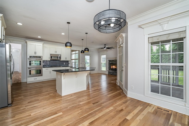 2804 Battleground Dr, Murfreesboro, TN 37129 - kitchen featuring appliances with stainless steel finishes, open floor plan, ornamental molding, a sink, and a breakfast bar area