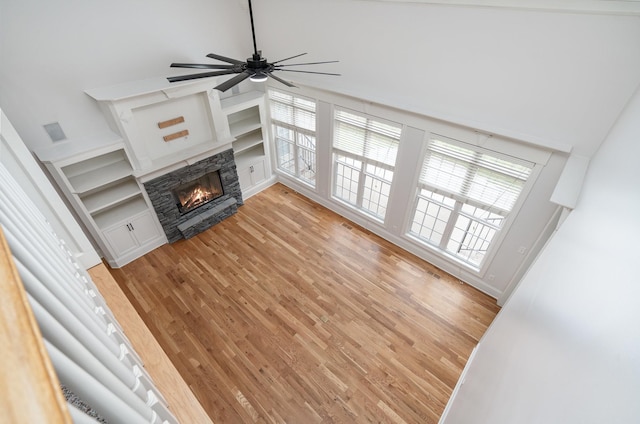 2804 Battleground Dr, Murfreesboro, TN 37129 - unfurnished living room featuring a stone fireplace, light wood-type flooring, ceiling fan, and a high ceiling