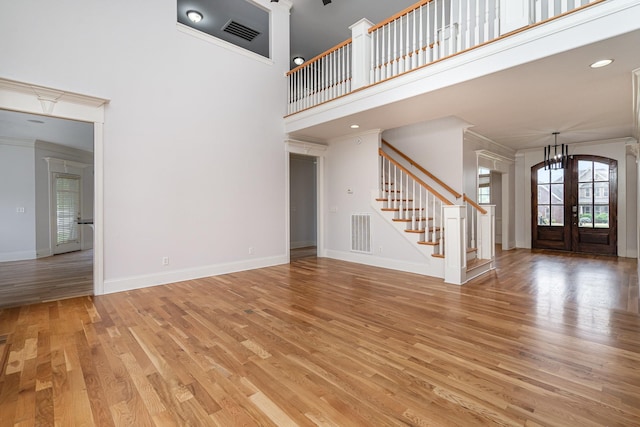2804 Battleground Dr, Murfreesboro, TN 37129 - unfurnished living room featuring stairway, ornamental molding, a towering ceiling, light wood-style flooring, and baseboards