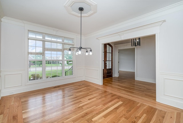 2804 Battleground Dr, Murfreesboro, TN 37129 - unfurnished dining area with a chandelier, light wood-style flooring, crown molding, a decorative wall, and wainscoting