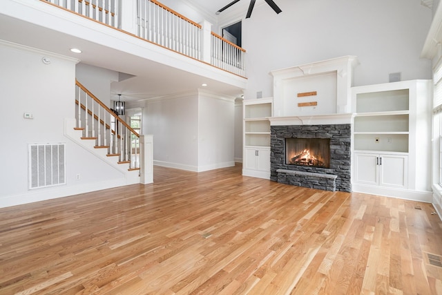 2804 Battleground Dr, Murfreesboro, TN 37129 - unfurnished living room with a high ceiling, light wood-type flooring, ceiling fan, a stone fireplace, and baseboards