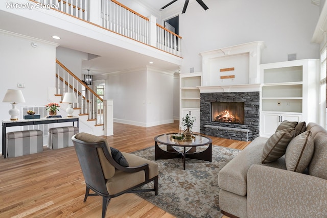 2804 Battleground Dr, Murfreesboro, TN 37129 - living area featuring a high ceiling, a fireplace, stairs, a ceiling fan, and wood finished floors