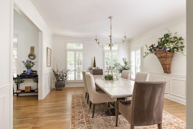 635 Band Dr, Franklin, TN 37064 - dining room with a chandelier, light wood finished floors, a decorative wall, crown molding, and a wainscoted wall