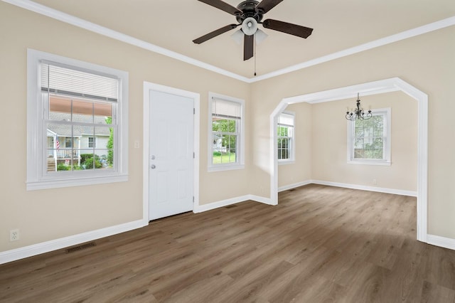 entryway featuring wood finished floors, a chandelier, baseboards, crown molding, and ceiling fan