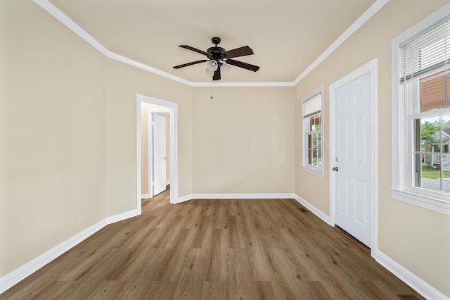 unfurnished room with wood finished floors, baseboards, a ceiling fan, and ornamental molding
