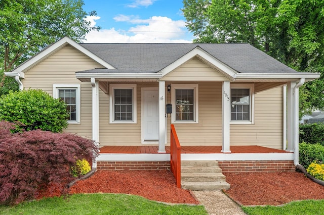 bungalow-style home with covered porch and roof with shingles