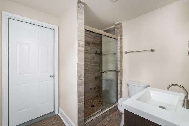 bathroom with a stall shower, toilet, baseboards, and vanity