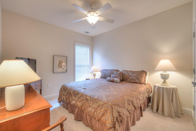 bedroom with light colored carpet, baseboards, and a ceiling fan