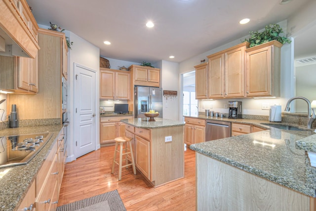 kitchen featuring a sink, appliances with stainless steel finishes, light brown cabinetry, light wood-style flooring, and recessed lighting