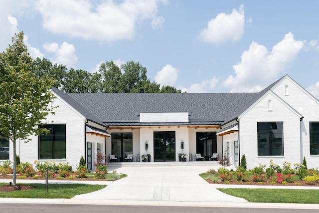 9052 Passiflora Ct, College Grove, TN 37046 - view of front facade featuring brick siding, a standing seam roof, concrete driveway, and metal roof
