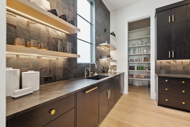 9052 Passiflora Ct, College Grove, TN 37046 - bar featuring a sink, light wood-style flooring, and backsplash
