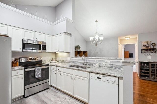 825 S Browns Ln Unit 1501, Gallatin, TN 37066 - kitchen featuring appliances with stainless steel finishes, a sink, a peninsula, light wood finished floors, and high vaulted ceiling