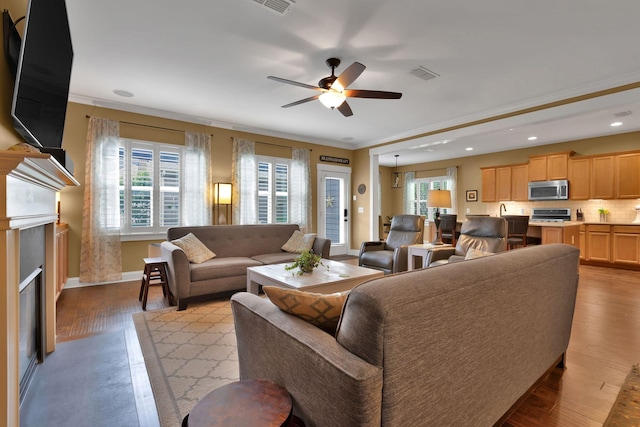 606 Tywater Crossing Blvd, Franklin, TN 37064 - living room with a ceiling fan, light wood-style floors, crown molding, a glass covered fireplace, and baseboards