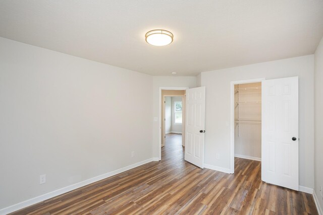 1011 Bon Meade Dr, Burns, TN 37029 - unfurnished bedroom with wood finished floors, baseboards, a closet, and a spacious closet