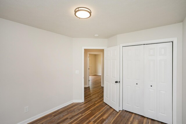 1011 Bon Meade Dr, Burns, TN 37029 - unfurnished bedroom with dark wood finished floors, baseboards, and a closet