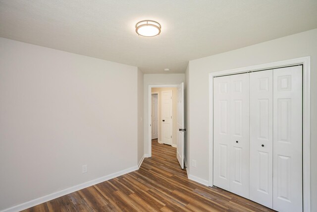 1011 Bon Meade Dr, Burns, TN 37029 - unfurnished bedroom featuring dark wood-style flooring, baseboards, and a closet