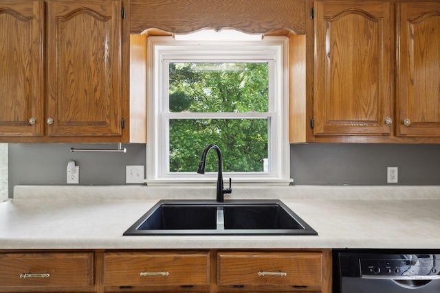 114 Clover Dr, Columbia, TN 38401 - kitchen with dishwashing machine, a sink, light countertops, and brown cabinets
