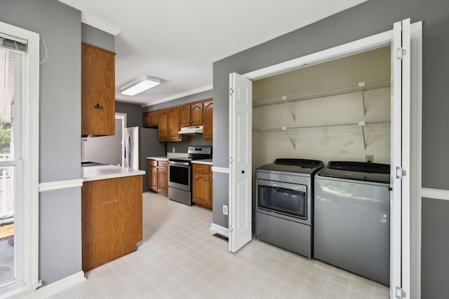 114 Clover Dr, Columbia, TN 38401 - kitchen featuring stainless steel range with electric cooktop, separate washer and dryer, under cabinet range hood, brown cabinets, and light countertops