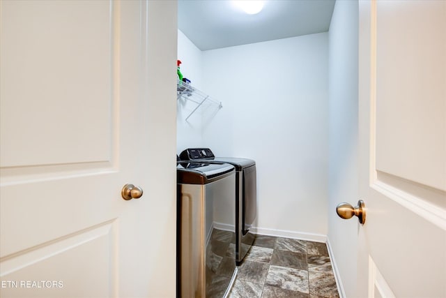 1242 Bill Wallace Dr, Friendsville, TN 37737 - laundry room with washer and clothes dryer, stone finish flooring, and baseboards