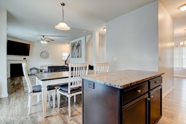 1242 Bill Wallace Dr, Friendsville, TN 37737 - kitchen featuring a ceiling fan, dark brown cabinetry, hanging light fixtures, and light wood finished floors