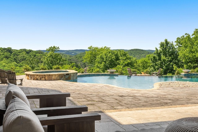 443 Canterbury Rise, Franklin, TN 37067 - view of swimming pool featuring a patio area, a pool with connected hot tub, a view of trees, and a mountain view