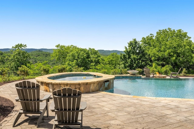 443 Canterbury Rise, Franklin, TN 37067 - view of swimming pool featuring a pool with connected hot tub, a patio area, and a wooded view