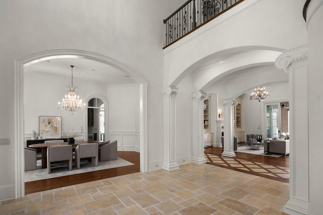 443 Canterbury Rise, Franklin, TN 37067 - entrance foyer with a chandelier, stone tile floors, a high ceiling, arched walkways, and ornate columns