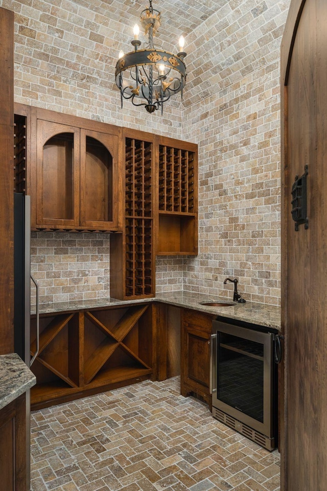 443 Canterbury Rise, Franklin, TN 37067 - wine cellar featuring wine cooler, brick ceiling, a sink, vaulted ceiling, and a chandelier